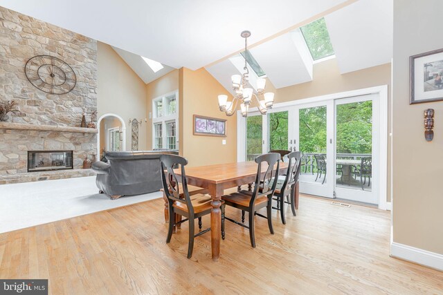 1052 Cedar Mill Ln, West Chester, PA 19382 - dining room with a skylight, a chandelier, light wood-type flooring, a stone fireplace, and high vaulted ceiling