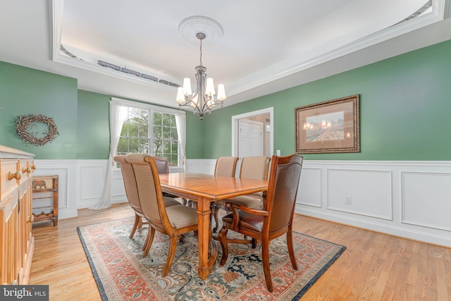 1052 Cedar Mill Ln, West Chester, PA 19382 - dining area with a chandelier, a raised ceiling, wainscoting, light wood-style flooring, and a decorative wall