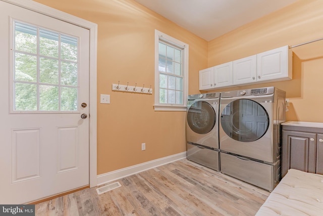 1052 Cedar Mill Ln, West Chester, PA 19382 - laundry area featuring cabinet space, separate washer and dryer, healthy amount of natural light, and light wood-style floors