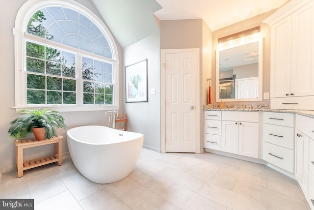 1052 Cedar Mill Ln, West Chester, PA 19382 - bathroom with vanity, a soaking tub, lofted ceiling, tile patterned flooring, and baseboards