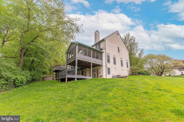 1052 Cedar Mill Ln, West Chester, PA 19382 - back of house featuring a sunroom, a chimney, a deck, a lawn, and stucco siding