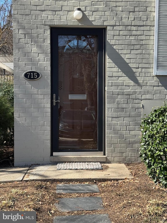 entrance to property featuring brick siding