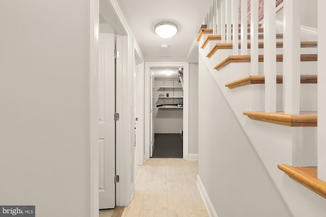 hall featuring light wood-type flooring and baseboards