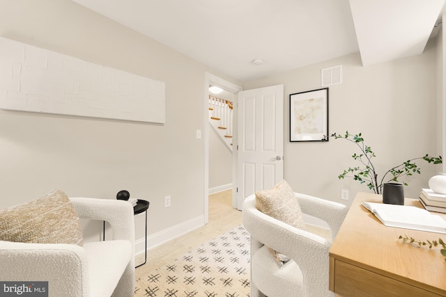 interior space with stairway, visible vents, light wood finished floors, and baseboards