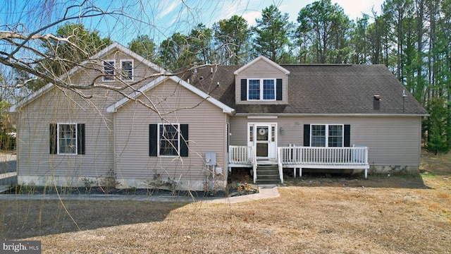 view of front facade featuring a wooden deck and a shingled roof