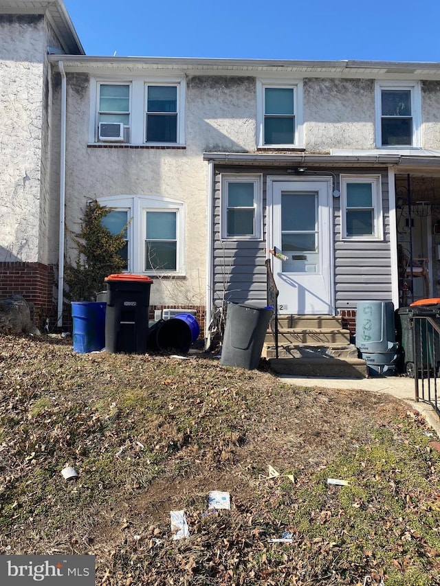 back of house featuring stucco siding and entry steps