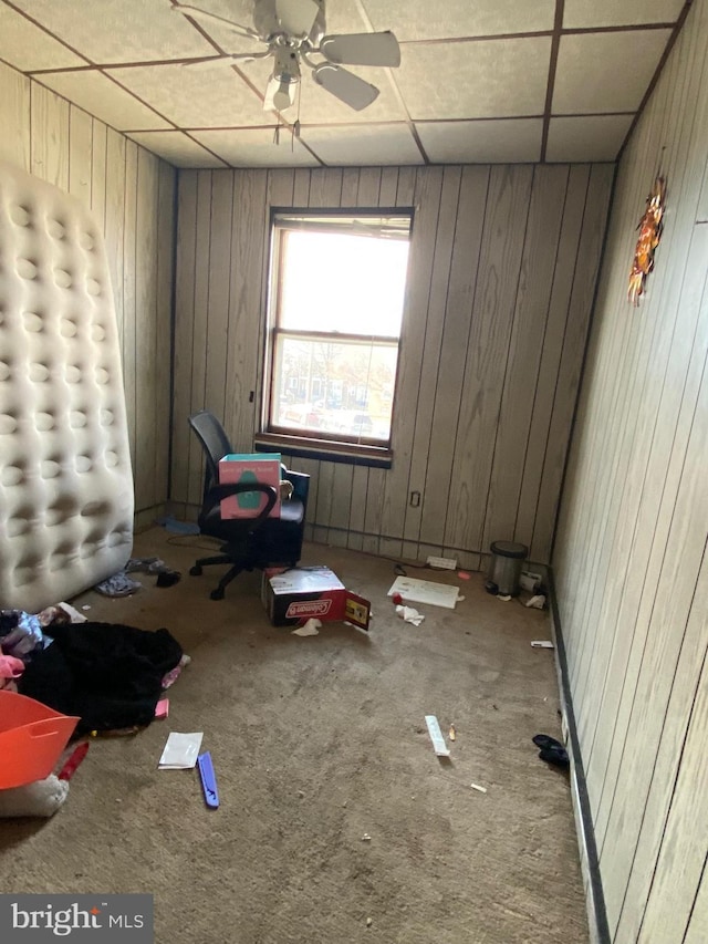 unfurnished bedroom featuring a paneled ceiling and wood walls