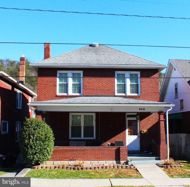 view of front of property with brick siding, covered porch, and a shingled roof