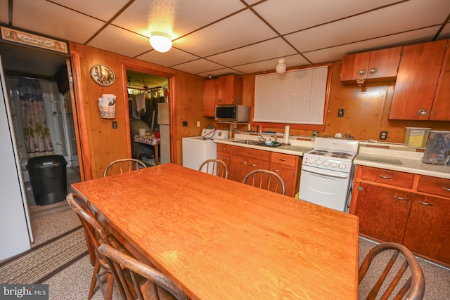 kitchen with a drop ceiling, washer / dryer, appliances with stainless steel finishes, and light countertops