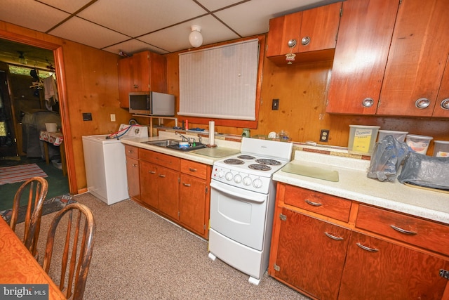 kitchen with stainless steel microwave, light countertops, electric stove, washer / clothes dryer, and a sink