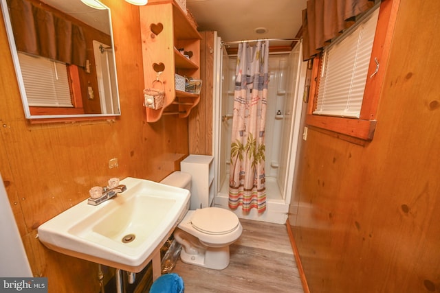 full bath featuring curtained shower, toilet, wood finished floors, and a sink