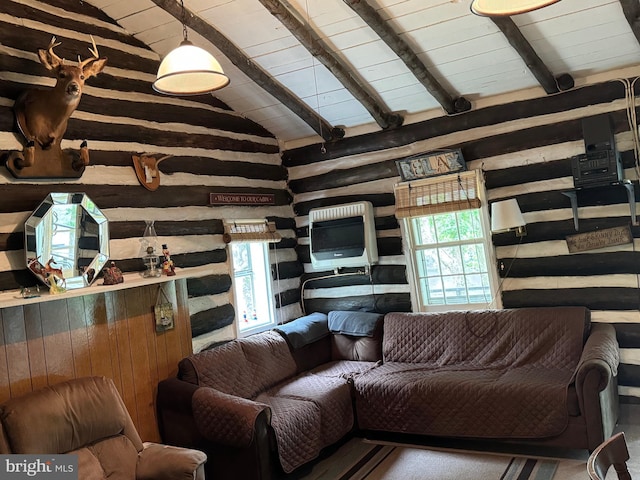 living area featuring vaulted ceiling with beams, plenty of natural light, and rustic walls