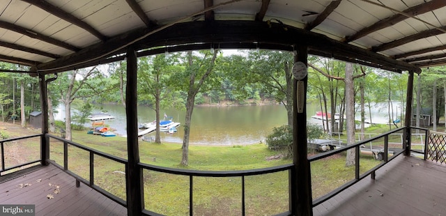 unfurnished sunroom featuring lofted ceiling with beams and a water view