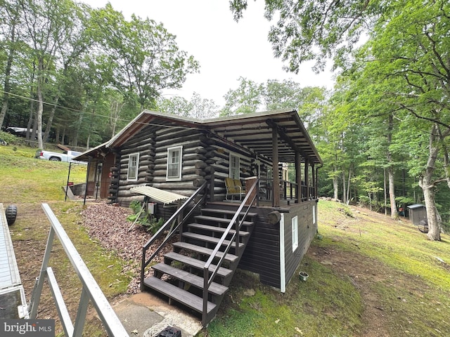 exterior space featuring log siding, stairway, and a wooden deck