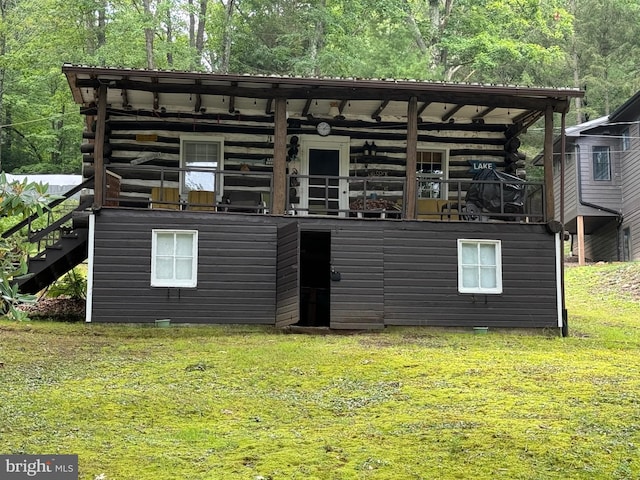 view of front of home with a front lawn, log exterior, and stairs