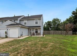 view of front of home with a front lawn, an attached garage, fence, and concrete driveway