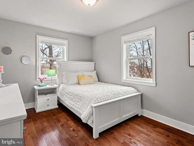 bedroom with dark wood-type flooring and baseboards