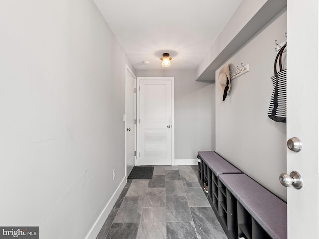 mudroom with stone finish floor and baseboards