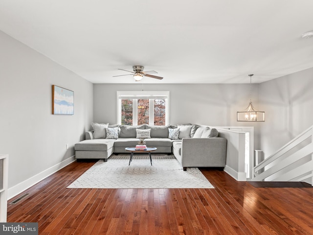 living room with visible vents, baseboards, dark wood finished floors, and ceiling fan with notable chandelier