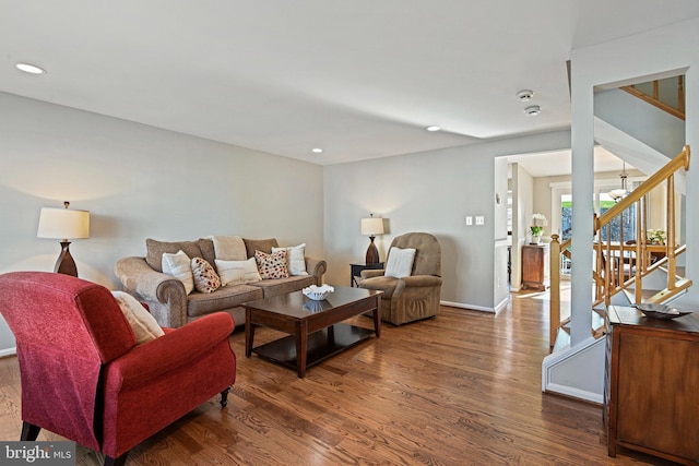 living room with recessed lighting, stairs, baseboards, and wood finished floors