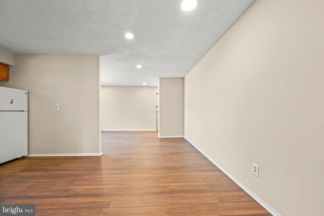 interior space featuring recessed lighting, freestanding refrigerator, baseboards, and wood finished floors