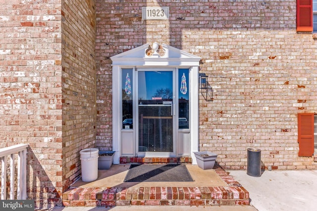 doorway to property with brick siding