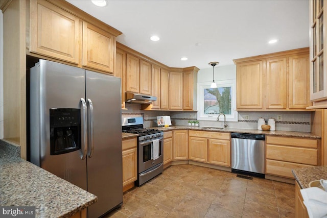 kitchen featuring tasteful backsplash, light brown cabinets, under cabinet range hood, stainless steel appliances, and a sink