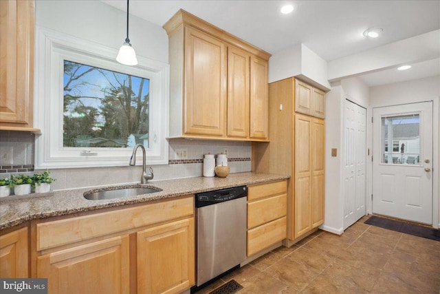 kitchen with stainless steel dishwasher, decorative backsplash, light brown cabinetry, and a sink