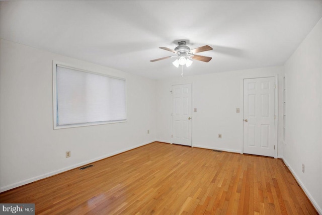 empty room with visible vents, ceiling fan, baseboards, and light wood-style floors