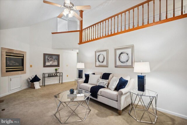 carpeted living area featuring baseboards, high vaulted ceiling, and a ceiling fan