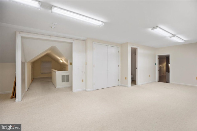 additional living space featuring carpet flooring, baseboards, and visible vents