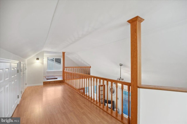 corridor with vaulted ceiling and wood finished floors