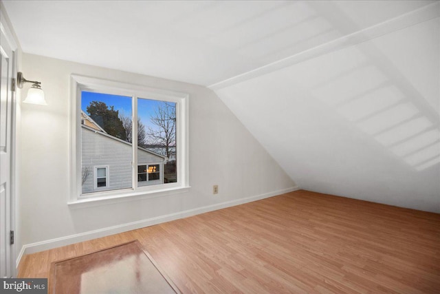 bonus room with vaulted ceiling, wood finished floors, and baseboards