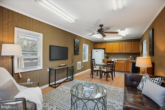 living area featuring ornamental molding, cooling unit, visible vents, and light wood-type flooring