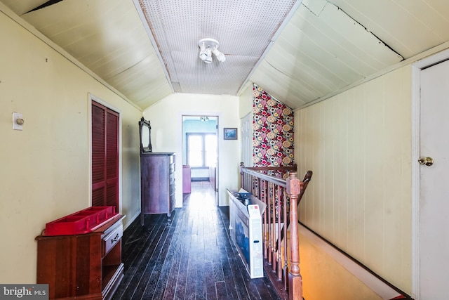 hallway featuring wood-type flooring, lofted ceiling, and an upstairs landing