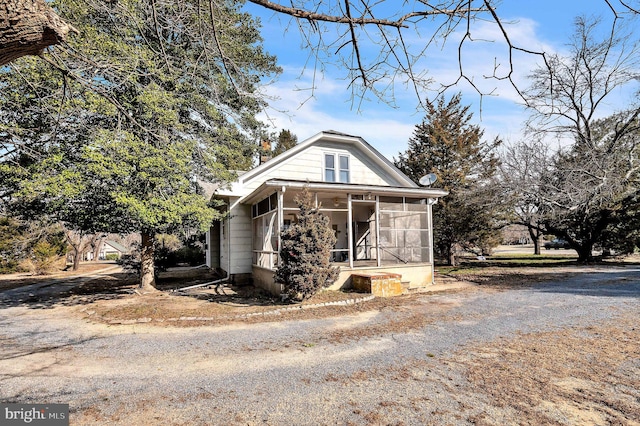 view of front of house with driveway and a sunroom