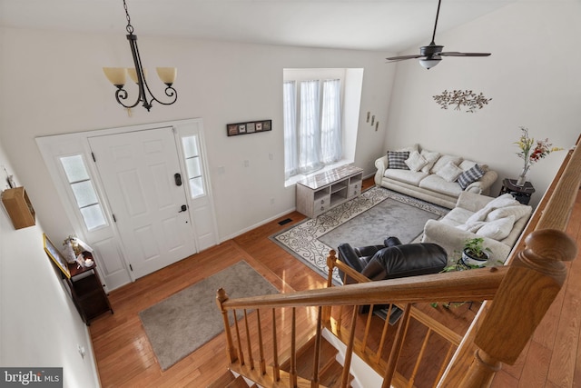 entrance foyer with ceiling fan with notable chandelier, wood finished floors, and visible vents