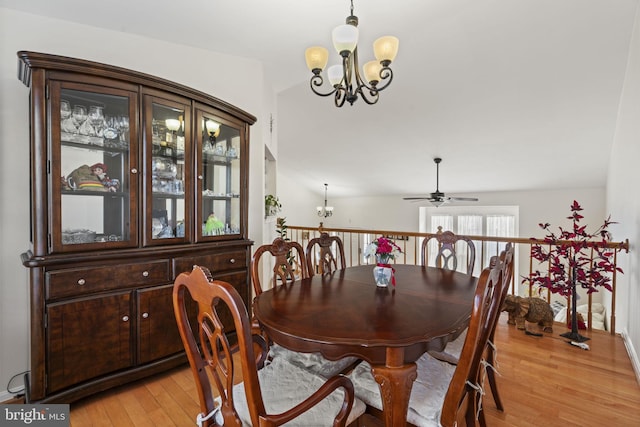 dining room featuring light wood-style flooring and ceiling fan with notable chandelier