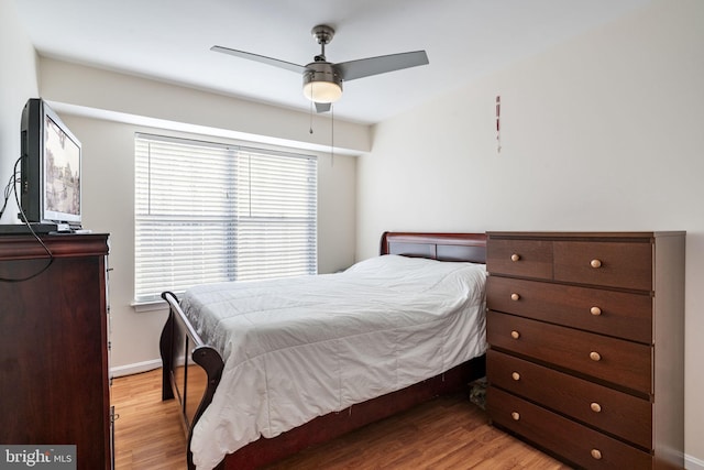 bedroom featuring wood finished floors, baseboards, and ceiling fan