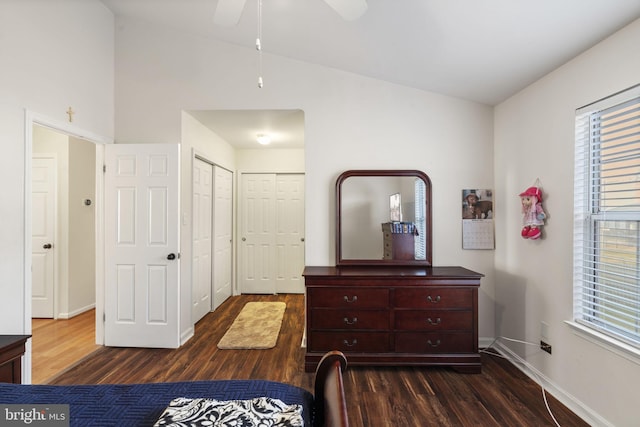 bedroom with dark wood-type flooring, multiple windows, and lofted ceiling