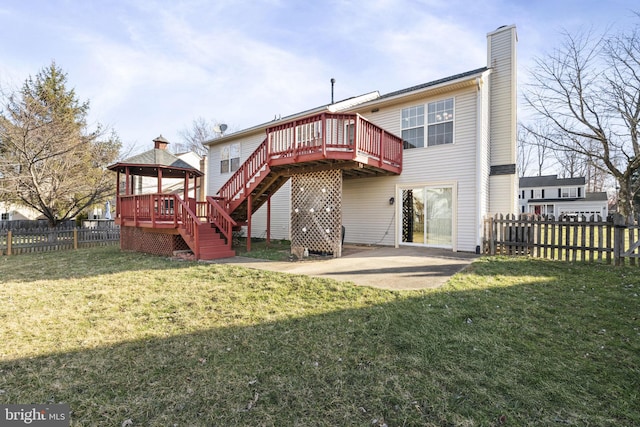 back of property with stairs, a fenced backyard, a lawn, and a wooden deck