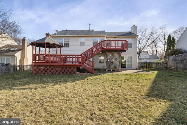 rear view of property featuring a deck, a fenced backyard, and a lawn