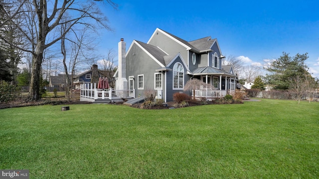 view of side of home with a shingled roof, a yard, and a chimney