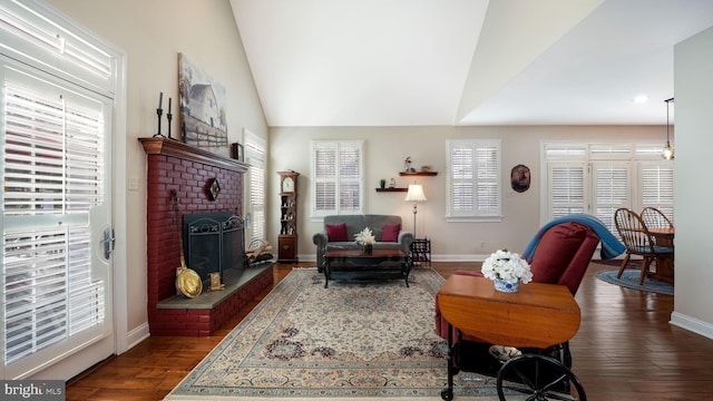 living area featuring a brick fireplace, baseboards, lofted ceiling, and dark wood-style flooring