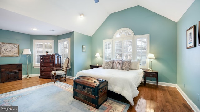 bedroom with lofted ceiling, baseboards, and wood finished floors