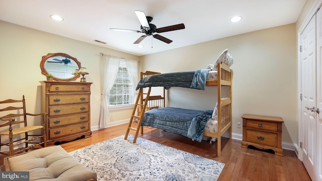 bedroom with recessed lighting, wood finished floors, visible vents, and a closet