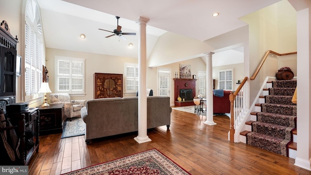 living room with hardwood / wood-style floors, a fireplace, decorative columns, lofted ceiling, and ceiling fan