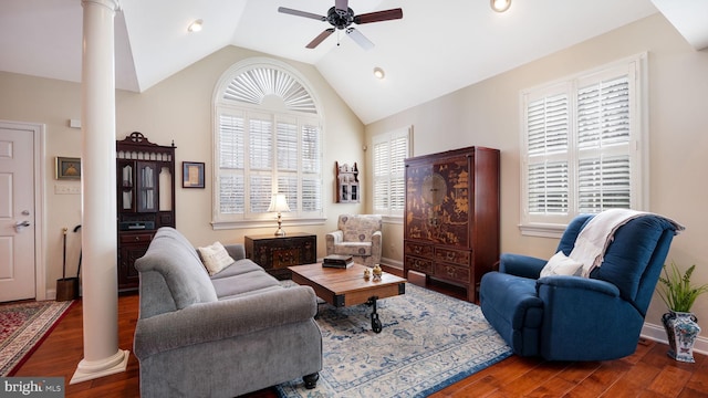 living room with wood finished floors, a ceiling fan, baseboards, ornate columns, and vaulted ceiling