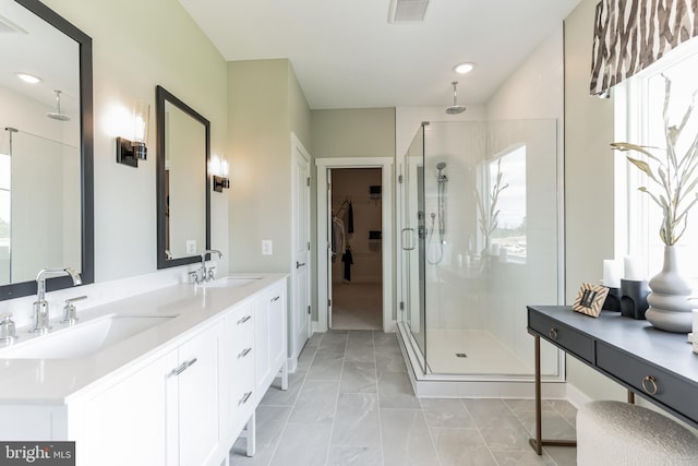 bathroom featuring a walk in closet, a shower stall, visible vents, and a sink