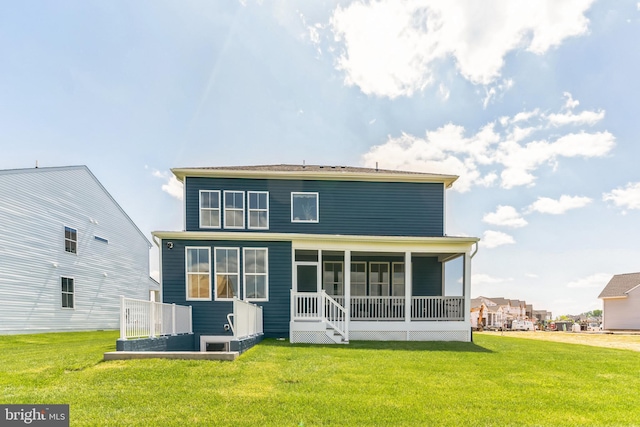 back of property with a yard and a sunroom